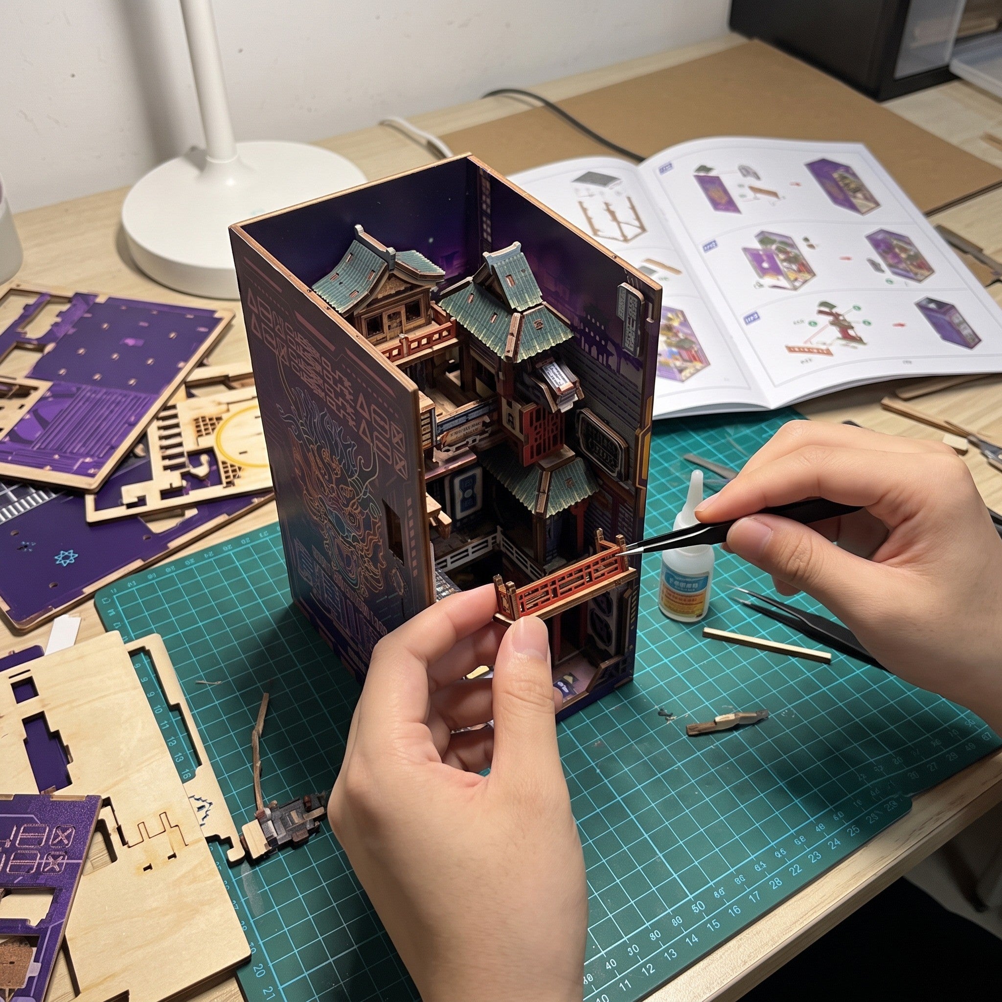 Hands fitting a tiny balcony on a craft mat